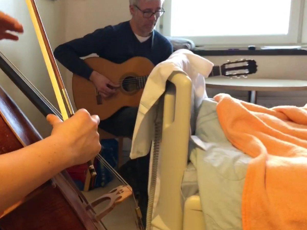 Två musiker vid sjukhussäng.
